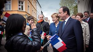 Bundeskanzlerin Angela Merkel, der französische Präsident François Hollande und Delegationsteilnehmer spazieren durch Stralsund.
