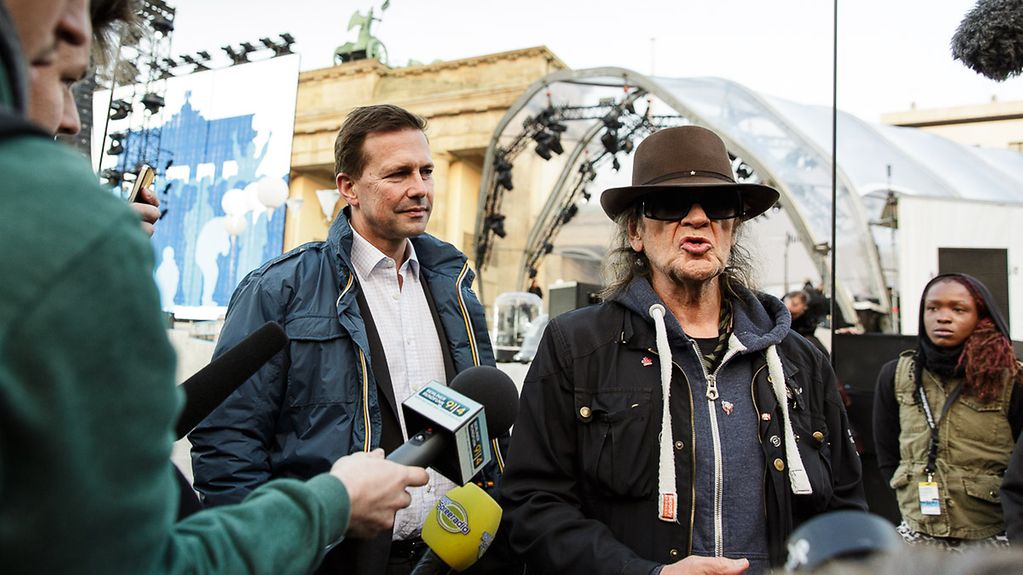 Devant la Porte de Brandebourg, le musicien et chanteur Udo Lindenberg donne une interview aux côtés du porte-parole du gouvernement fédéral, Steffen Seibert