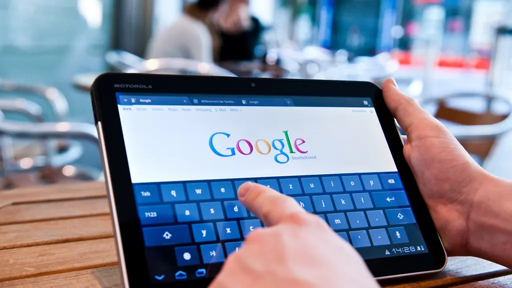 Ein Mann surft auf dem Tablet im Internet.