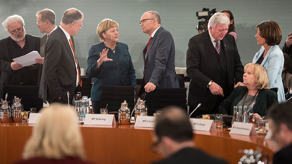 Bundeskanzlerin Angela Merkel unterhält sich zu Beginn einer Sitzung mit den Regierungschefs der Länder mit Mecklenburg-Vorpommerns Ministerpräsident Erwin Sellering.