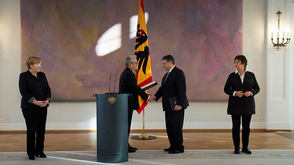 Federal President Joachim Gauck presents Federal Minister for Foreign Affairs Sigmar Gabriel with his certificate of appointment - in the presence of Chancellor Angela Merkel and Brigitte Zypries.