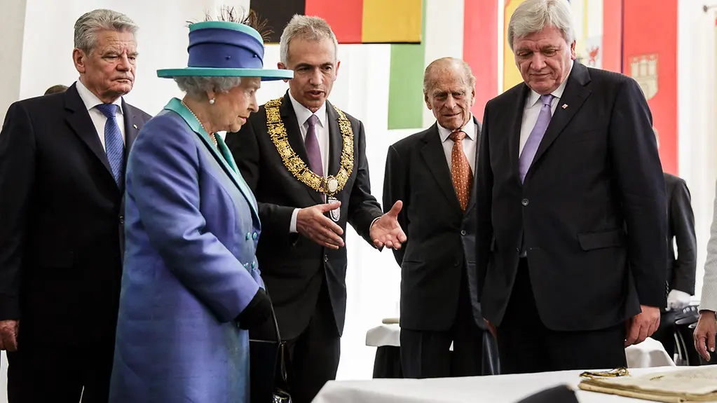 Frankfurt's Lord Mayor Peter Feldmann and Hesse's State Premier Volker Bouffier welcome the Queen and the Duke of Edinburgh.