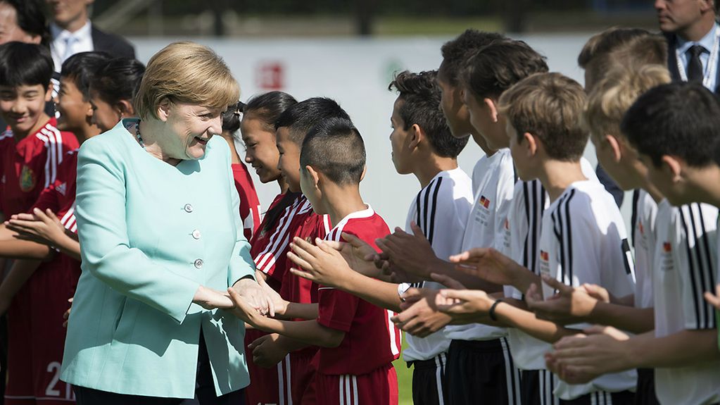 Angela Merkel gives the players a "low-five."