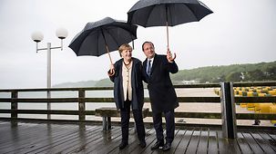 Bundeskanzlerin Angela Merkel und der französische Präsident François Hollande stehen in Binz auf der Seebrücke.
