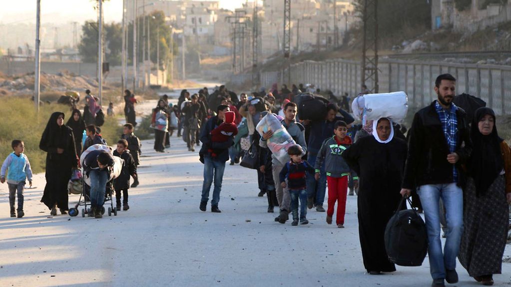 Syrische Menschen fliehen zu Fuß aus Ost-Aleppo