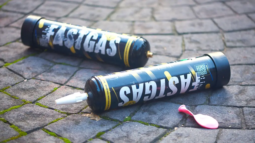 Zwei Gasflaschen mit der Aufschrift "Fastgas" liegen auf Kopfsteinpflaster. 