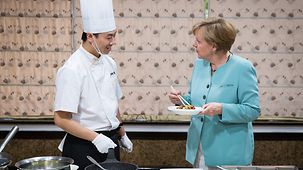 Bundeskanzlerin Angela Merkel beim Besuch einer Küche.