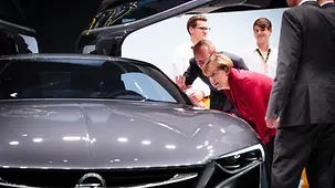 Bundeskanzlerin Angela Merkel schaut ins Innere eines Opel.