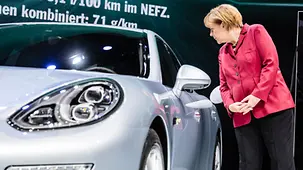 Bundeskanzlerin Angela Merkel sieht sich einen Hybrid-Porsche an.