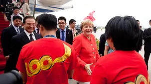 Merkel und Wen schütteln Airbus-Mitarbeitern die Hände.