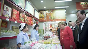 Merkel betrachtet die angebotenen Waren.