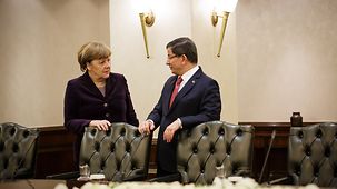 Bundeskanzlerin Angela Merkel und der türkische Ministerpräsident Ahmet Davutoglu gehen nebeneinander.
