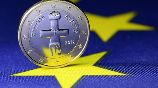 Ein-Euro-Münze aus Zypern auf einer EU-Fahne