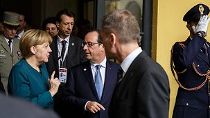 Chancellor Angela Merkel talks with French President François Hollande.