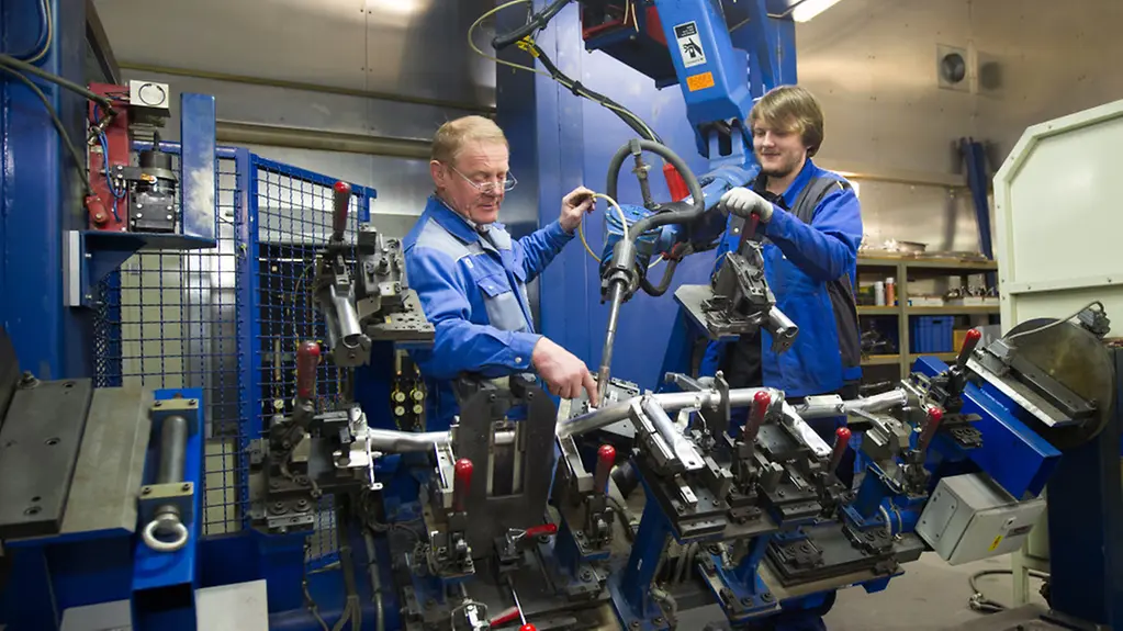 Mitarbeiter bei einem Schweißroboter.