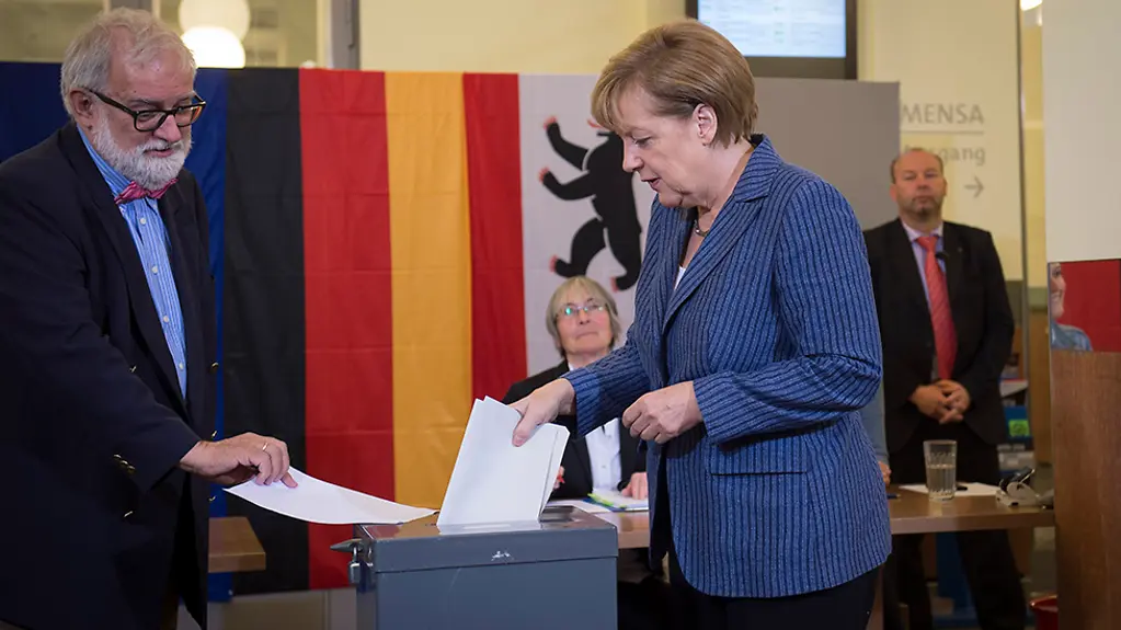 Bundeskanzlerin Angela Merkel beim Einwurf der Stimmzettel in die Wahlurne in einem Berliner Wahllokal.