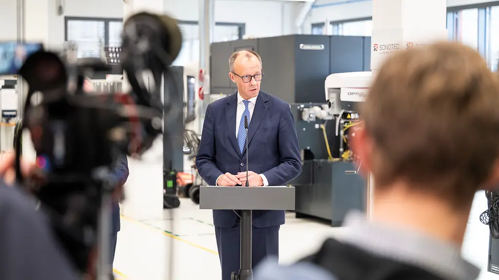 Bundeskanzler Merz am Rednerpult für ein Statement beim Länderbesuch in Sachsen-Anhalt