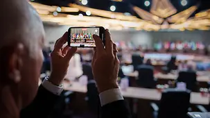 The photo shows a G20 meeting on the display of a mobile phone.