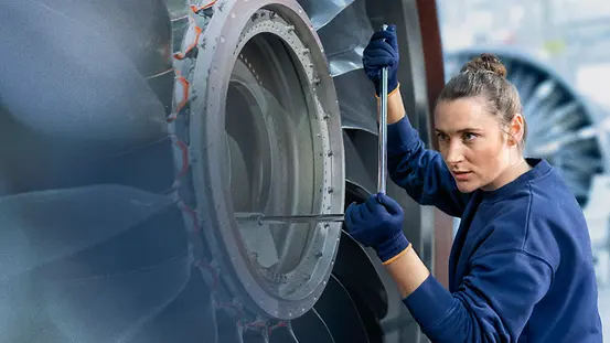 Eine Frau arbeitet an einer Turbine. 