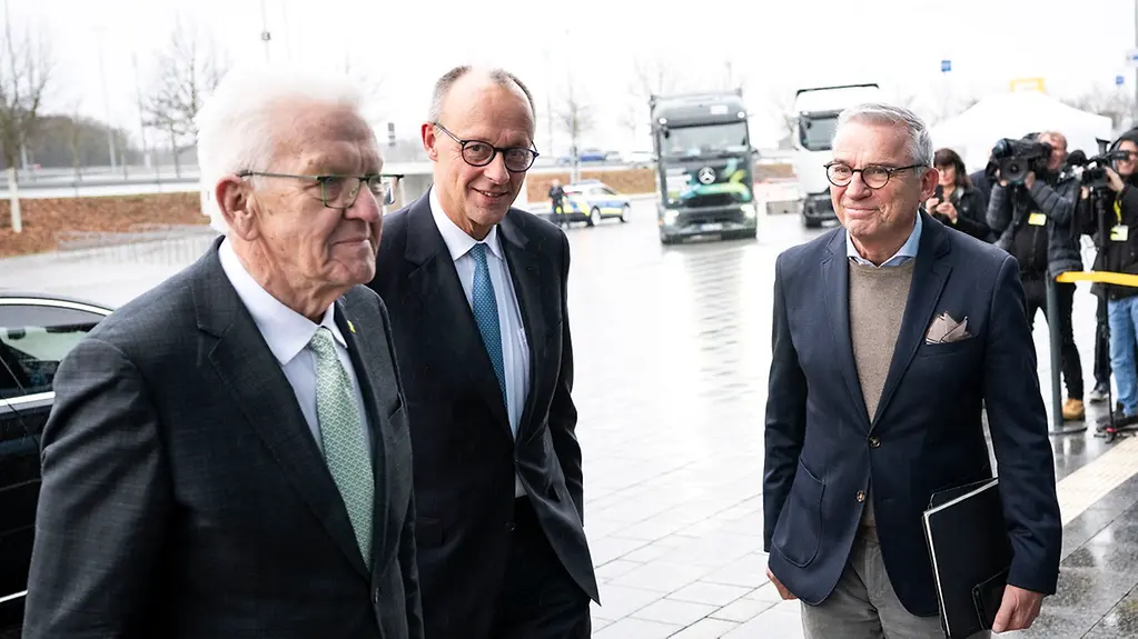 Bundeskanzler Merz betritt zusammen mit Winfried Kretschmann und Thomas Strobl den Veranstaltungsort.