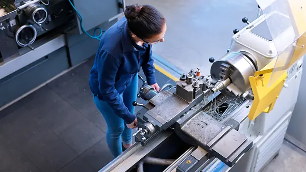 Eine Frau an einer metallverarbeitenden Maschine
