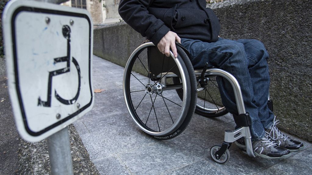 Ein Rollstuhl-Fahrer fährt eine Rampe hoch.