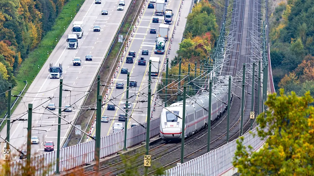 Côte à côte, des voies ferrées et une autoroute