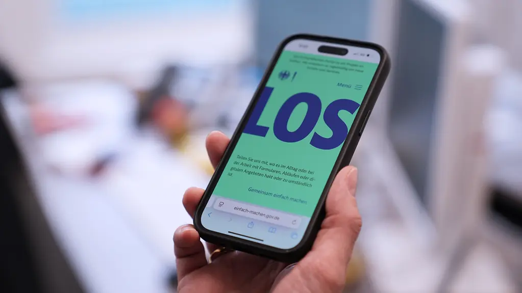 Eine Person ruft die Webseite auf dem Handy ab.