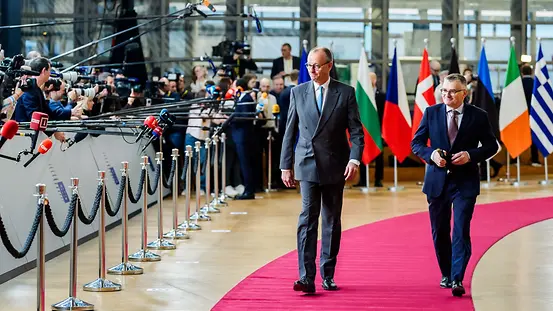 Bundeskanzler Merz vor Mikrofonen im Eingangsbereich des Europäischen Rats.