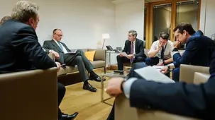 Das Foto zeigt Bundeskanzler Friedrich Merz mit seinen Beratern beim Treffen des EU-Rats