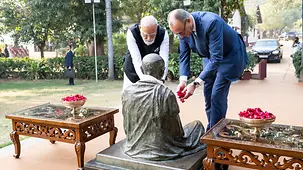 Bundeskanzler Merz und Indiens Premierminister Modi legen an einer Gandhi-Statue Blumen nieder.