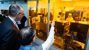 Das Foto zeigt Bundeskanzler Friedrich Merz im Zentrum für Nanowissenschaften und -technik vor einem Reinraum.