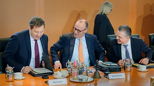 Das Foto zeigt Bundeskanzler Friedrich Merz zwischen Lars Klingbeil, Bundesminister der Finanzen, und Thorsten Frei, Chef des Bundeskanzleramtes und Bundesminister für besondere Aufgaben, zu Beginn einer Kabinettssitzung.