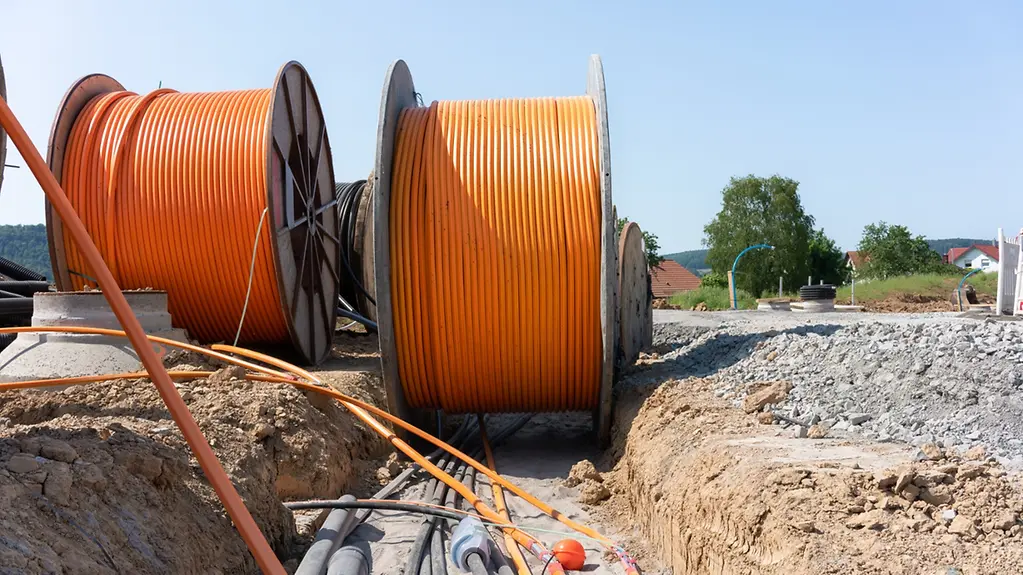 Kabeltrommeln mit Leitungen für Breitbandkabel stehen auf einer Baustelle.