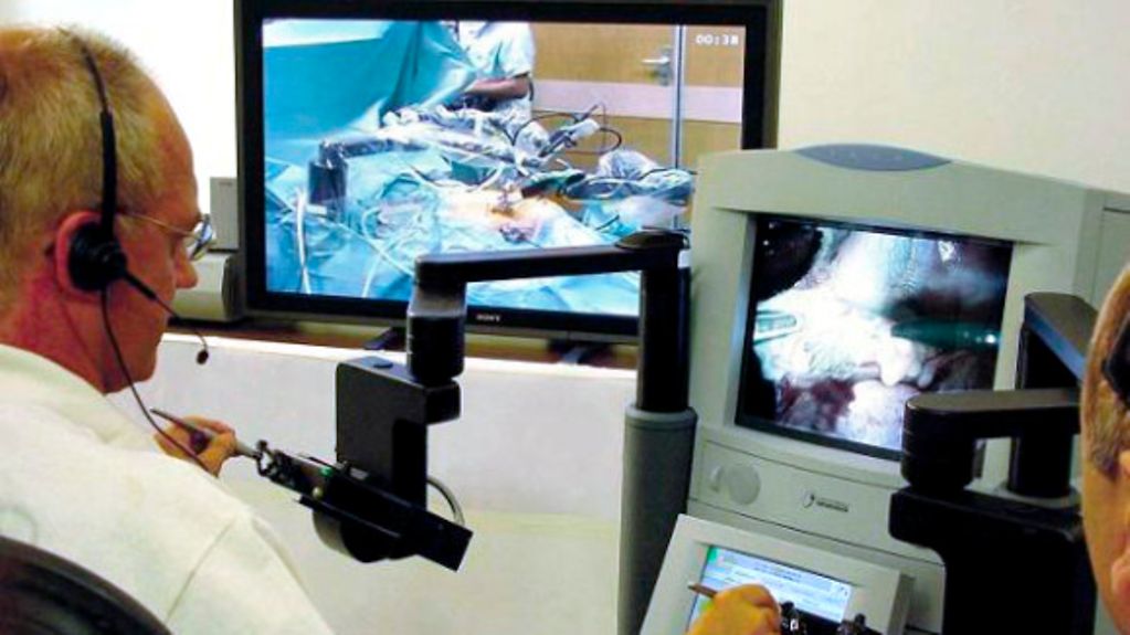 Mit Hilfe eines ferngesteuerten Roboters entfernt ein Chirurg die Gallenblase