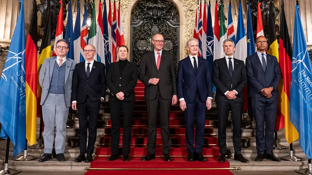 Familienfoto mit Bundeskanzler Merz und den Teilnehmern des Nordsee-Gipfels vor dem Hamburger Rathaus.