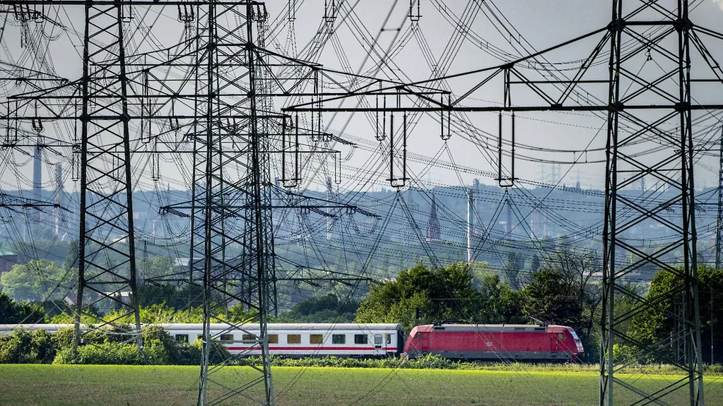 Electricity pylons and an express train.