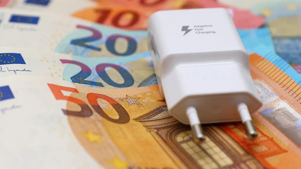 Stromstecker auf Geldscheinen.