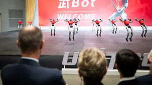 The photo shows Federal Chancellor Friedrich Merz at a demonstration of humanoid robots.