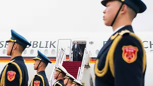 Le chancelier fédéral Merz descendant de l’avion gouvernemental ; au premier plan, une garde d’honneur chinoise.
