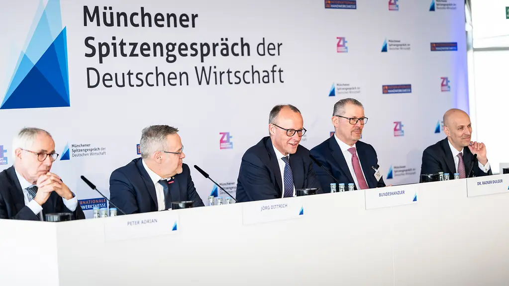 Das Foto zeigt Bundeskanzler Friedrich Merz mit Vertretern von Wirtschaftsverbänden beim Münchner Spitzengespräch.