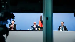 Bundeskanzler Friedrich Merz bei einer G7-Videokonferenz zwischen seinen Beratern Levin Holle und Günter Sautter.