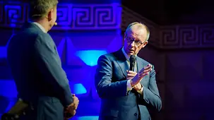 Bundeskanzler Friedrich Merz im Gespräch auf der Bühne im Kurhaus Wiesbaden beim Festakt zum 75-jährigen Bestehen des Bundeskriminalamtes.