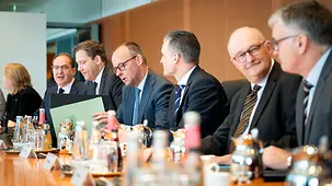 Bundeskanzler Friedrich Merz liest zu Beginn der Kabinettssitzung zwischen seinen Kollegen in Unterlagen.
