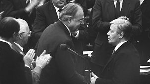 In the German Bundestag, former Federal Chancellor Helmut Schmidt (at right) congratulates Helmut Kohl on becoming Chancellor.