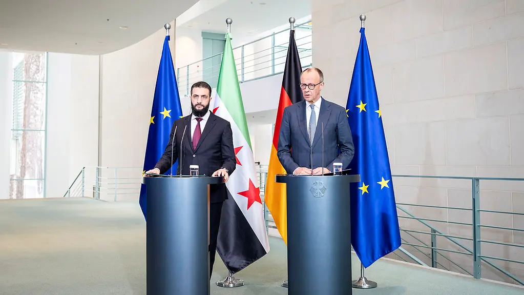 Bundeskanzler Friedrich Merz und der syrische Präsident Ahmed al-Scharaa am Rednerpult im Kanzleramt.