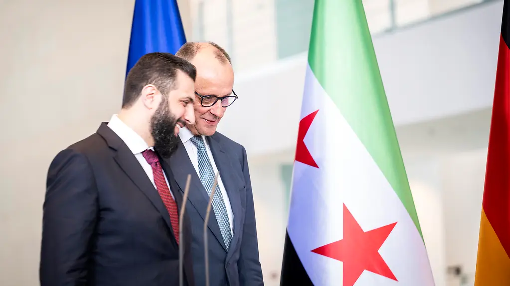 Bundeskanzler Merz und Ahmed Al-Scharaa sprechen locker miteinander.