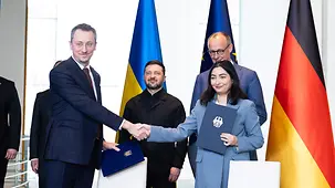 Kanzler Merz und Präsident Selenskyj hinter den Entwicklungsministerinnnen und -ministern ihrer Länder.