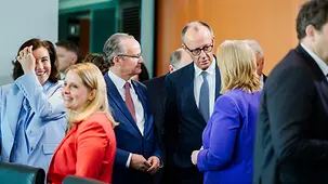 Bundeskanzler Friedrich Merz im Gespräch mit Bärbel Bas, Bundesministerin für Arbeit und Soziales, und anderen Kabinettskollegen im Vorfeld einer SItzung.