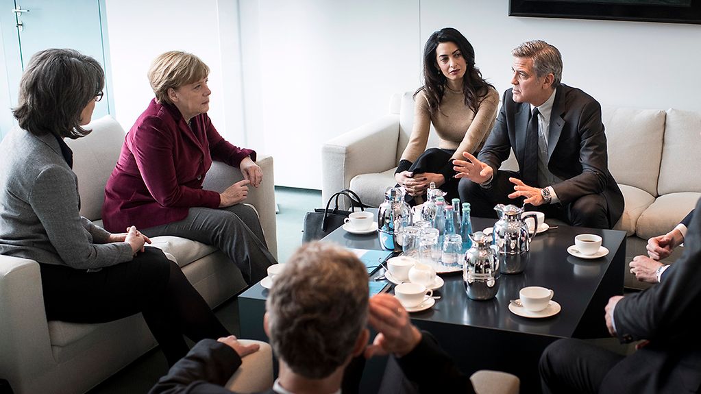 Bundeskanzlerin Angela Merkel im Gespräch mit Amal und George Clooney.